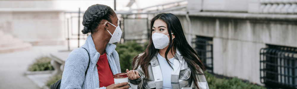 two female students walking outside wearing masks during covid