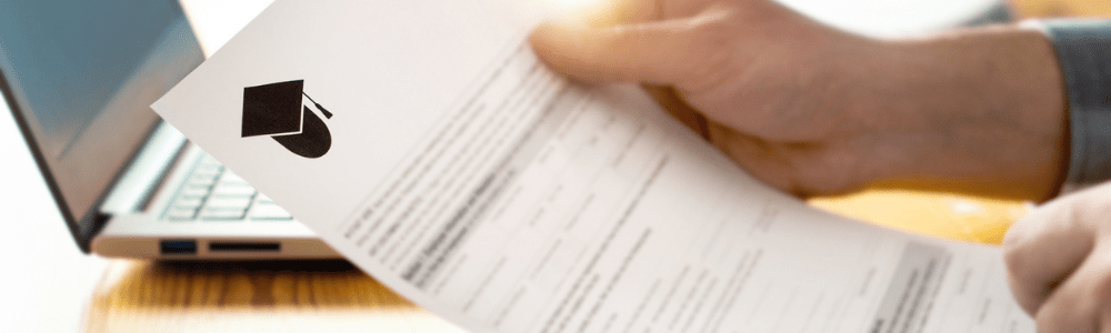 hands holding financial aid letter with laptop in background