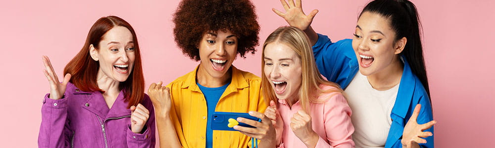 Four excited girls looking at a phone