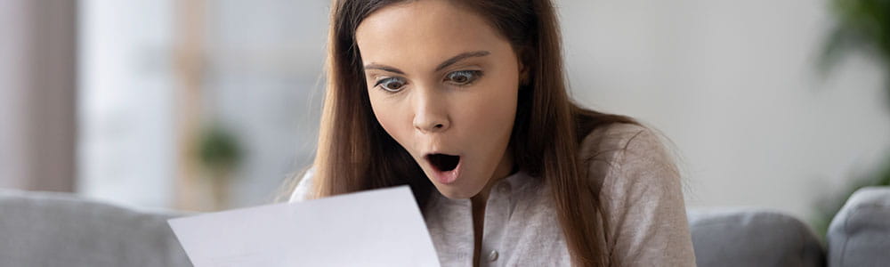 Surprised college student looking at her bill