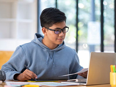 Male student studying at a desk in his college library