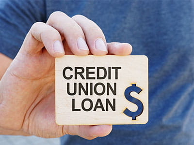 hand holding a card that says credit union loan