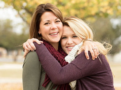 Mom and daughter hugging as mom helps her go to college with a parent student loan