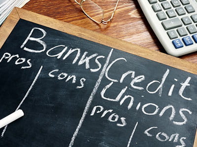 Chalkboard that is comparing pros and cons of banks vs credit unions