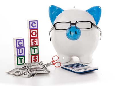 debt management - piggy bank with calculator and scissors with blocks spelling out cut costs