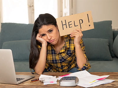 Distressed female student with help sign as she worries about finding money for college
