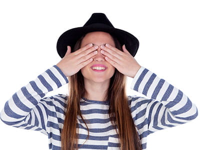 Female Student with hands covering her eyes to convey concept of need blind college admissions