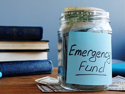 Savings - Jar of money with label that says emergency fund