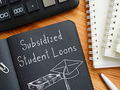 Notebook with Subsidized student loans written inside