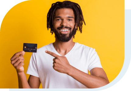 Young man pointing to a credit card he is holding excited that he has his first Credit Card 